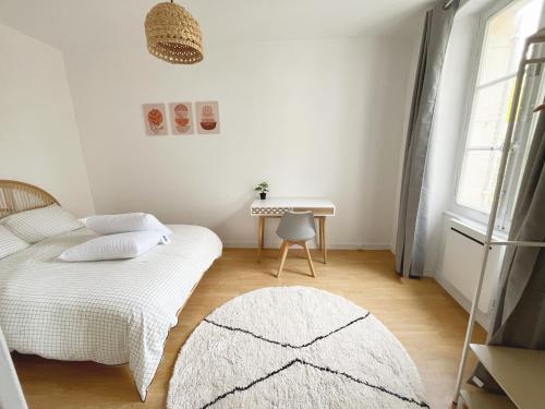 une chambre blanche avec un lit et une table dans l'établissement Le Cocon Angevin, à Angers