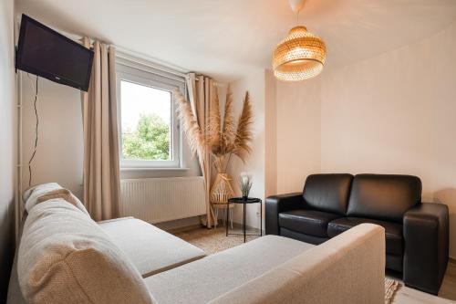 a living room with a couch and a television at Studio in villa Leeuwerik in De Panne