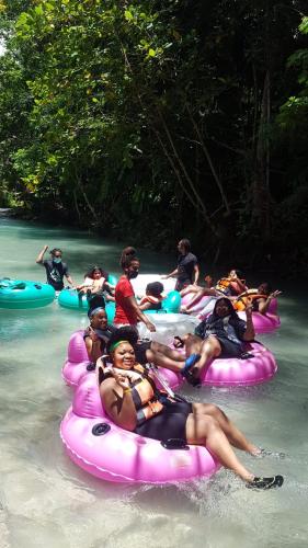 a group of people tubing down a river on tubes at Idilio Escape in Ocho Rios