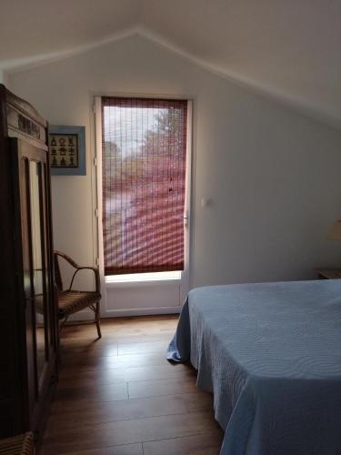 une chambre avec un lit et une grande fenêtre dans l'établissement Maison de pêcheur, à La Tremblade