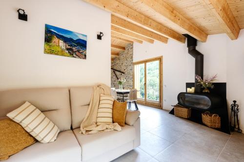 a living room with a couch and a tv at Cal Periquet Rural in Ribes de Freser