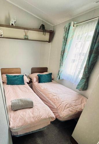 two beds in a small room with a window at Lovely 3 bedroom holiday home in Seton Sand caravan park Wi-Fi Xbox in Edinburgh