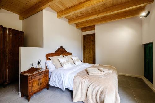 a bedroom with a large bed with white sheets and pillows at Cal Periquet Rural in Ribes de Freser