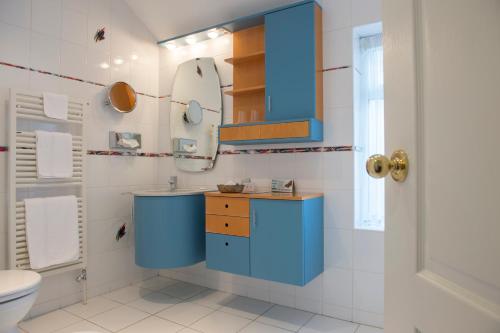 a bathroom with a blue sink and a mirror at Regency Hotel in Douglas