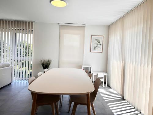 a white dining room with a white table and chairs at Appartement de charme in Vaux-sur-Sûre