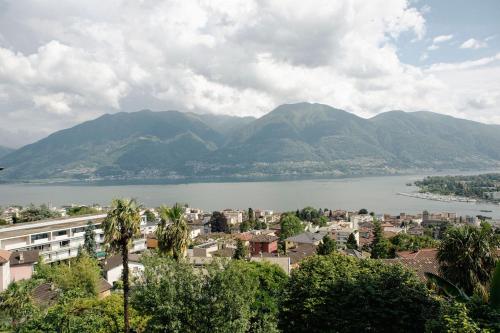 a city with a lake and mountains in the background at Casa Isabella App 2403 in Muralto