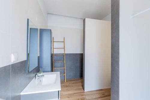 een badkamer met een witte wastafel en een ladder bij Cantinho do Barreiro - Calheta in Calheta