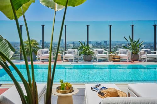 a pool with chaise lounge chairs and a resort at The Sun Rose West Hollywood in Los Angeles