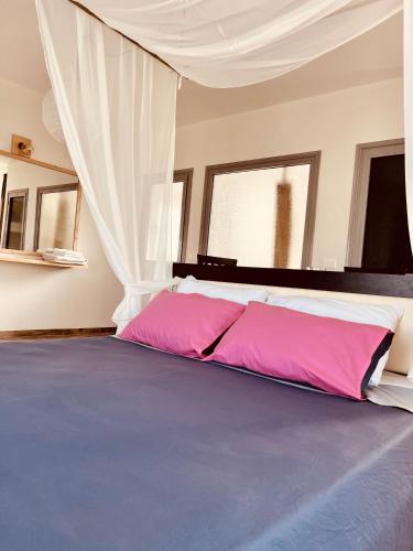 a bedroom with a large bed with pink sheets at Family Tree - WATER Available - SELF check in in Golem