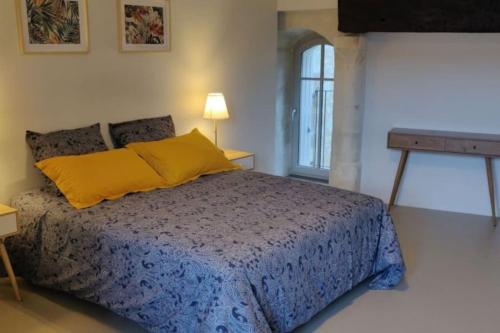 une chambre avec un lit avec une couette bleue et une fenêtre dans l'établissement Gîte à Saint-Sauveur, à Saint-Sauveur