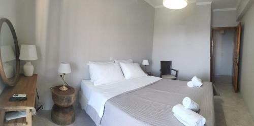 a bedroom with a large bed with white sheets and pillows at Avra in Parga