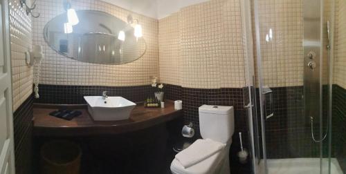 a bathroom with a toilet and a sink and a shower at Avra in Parga