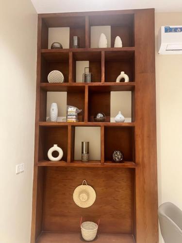 a wooden shelf with vases and other items on it at فندق دبليو سويتس - سما أبها in Abha