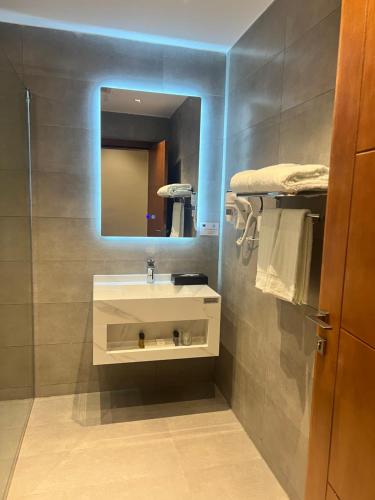 a bathroom with a white sink and a mirror at فندق دبليو سويتس - سما أبها in Abha
