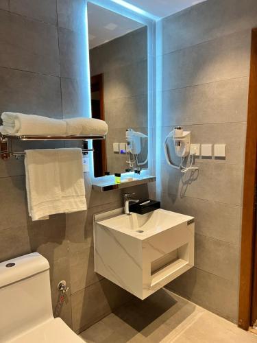 a bathroom with a sink and a toilet and a mirror at فندق دبليو سويتس - سما أبها in Abha
