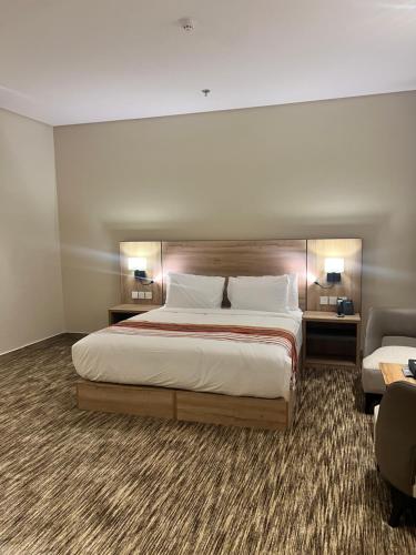 a bedroom with a large bed and two chairs at فندق دبليو سويتس - سما أبها in Abha