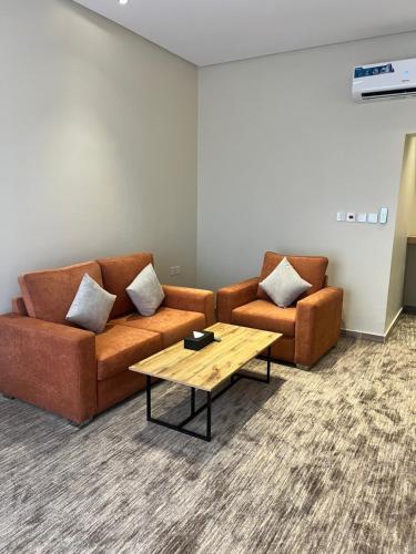 a living room with two couches and a coffee table at فندق دبليو سويتس - سما أبها in Abha