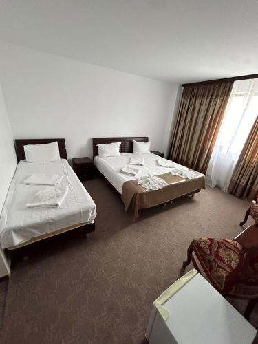a hotel room with two beds and a window at Orient Mamaia Nord in Mamaia Sat/Năvodari