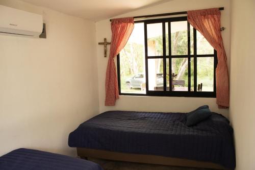 a bedroom with a bed and a window at El Prado- Casa Maya y Casa Rancho-10 personas in Hoctún