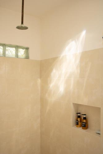 a bathroom with a shower with two bottles of soap at El Prado- Casa Maya y Casa Rancho-10 personas in Hoctún