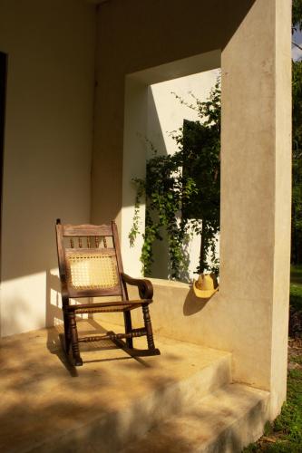 a chair sitting on the porch of a house at El Prado- Casa Maya y Casa Rancho-10 personas in Hoctún