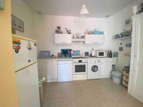 une cuisine avec des armoires blanches et une machine à laver dans l'établissement Villa Brise Lame - Accès direct plage, à Wimereux