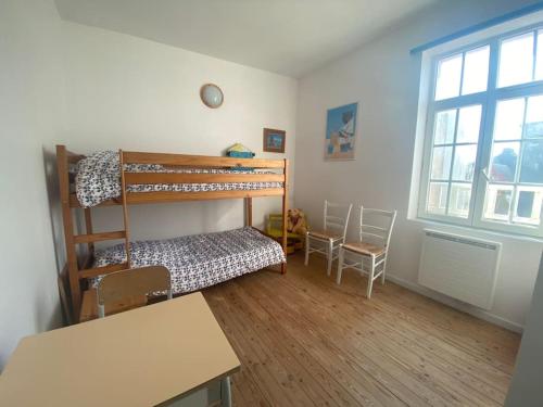 Cette chambre dispose de lits superposés, d'une table et d'un bureau. dans l'établissement Villa Brise Lame - Accès direct plage, à Wimereux