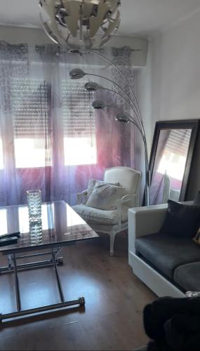 un salon avec un canapé et une table en verre dans l'établissement Joli appartement Quartier tranquille 13008 à 2 minutes du métro Perier, à Marseille