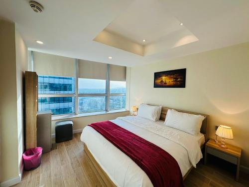 a bedroom with a large bed and a large window at Centaurus Apartment in Islamabad