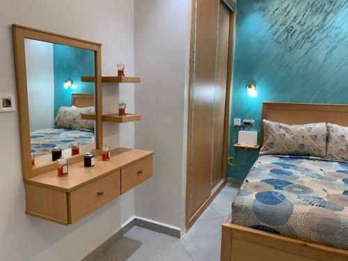Un dormitorio con una cama y un espejo grande. en Superbe Studio vue piscine, en Tánger