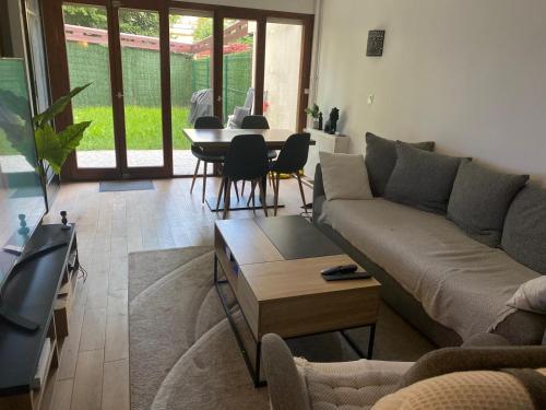 un salon avec un canapé et une table dans l'établissement Chambre disponible chez l'habitant - avec parties communes, Évry-Courcouronnes