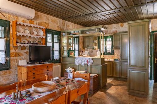 a kitchen with wooden cabinets and a tv in it at Liodentro - Olea in Plataria