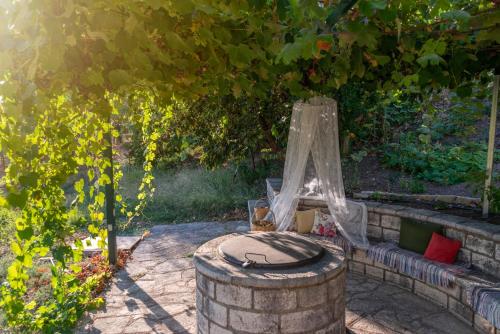 a bench with a canopy and a table under a tree at Liodentro - Olea in Plataria