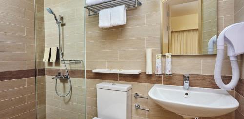 y baño con aseo, lavabo y ducha. en Genting Hotel Jurong, en Singapur