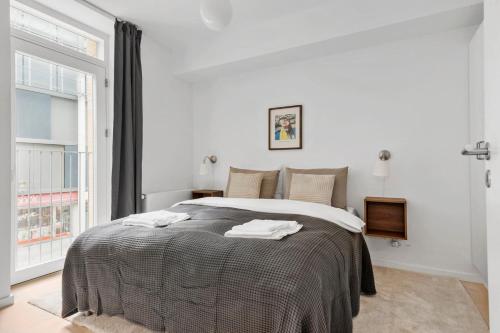 a white bedroom with a bed with towels on it at Spacious 2BR Inner City Apartment for 6 People in Aarhus