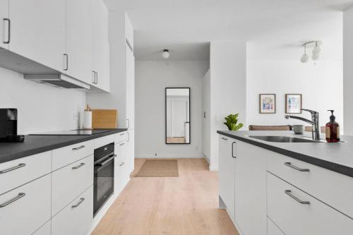 a white kitchen with white cabinets and a sink at Spacious 2BR Inner City Apartment for 6 People in Aarhus