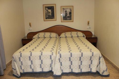 a bedroom with a large bed with two pillows at Hostal La Barretina in Figueres