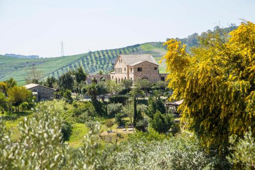 a large house in the middle of a field of trees at Agriturismo Fassi in Guardavalle