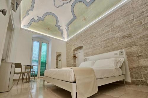 a bedroom with a large white bed and a ceiling at Relais La Muraglia - Central Luxury Rooms - Molfetta in Molfetta