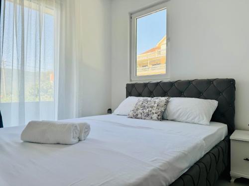 a bedroom with a large bed with a large window at Apartmani Asovic in Budva