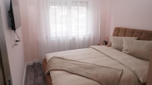a bedroom with a large bed and a window at FRATU Apartment in Făgăraş