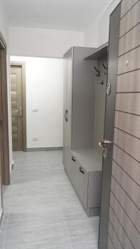 a white bathroom with a sink and a mirror at FRATU Apartment in Făgăraş