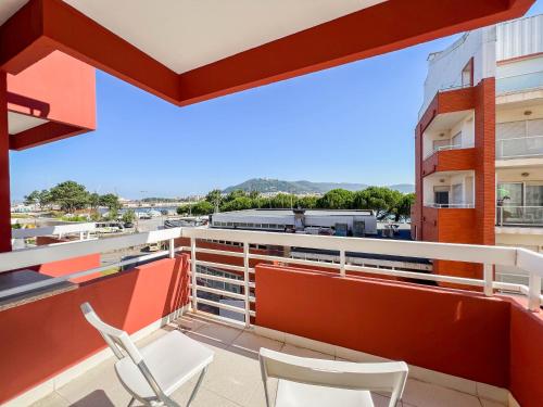 a balcony with two chairs and a view of a city at Cabedelo Beach Condo in Viana do Castelo