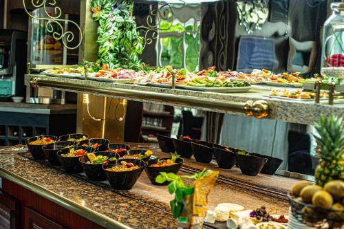 a buffet line with many trays of food at Logis Hôtel - Le Relais du Parisis in Villeparisis