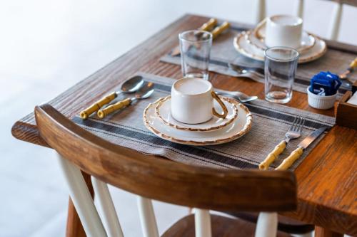 a wooden table with plates and cups on it at Casatua Pousada in Juquei