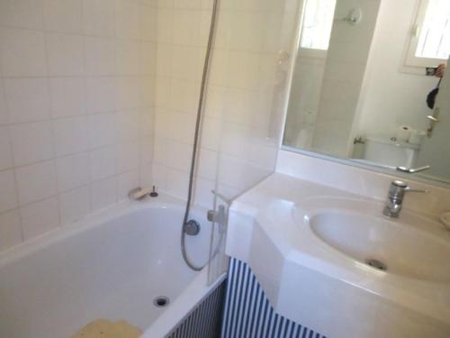 une salle de bain avec une baignoire, un lavabo et un miroir dans l'établissement VILLA 2 CHAMBRES dans RESIDENCE avec PISCINE, à Cavalaire-sur-Mer