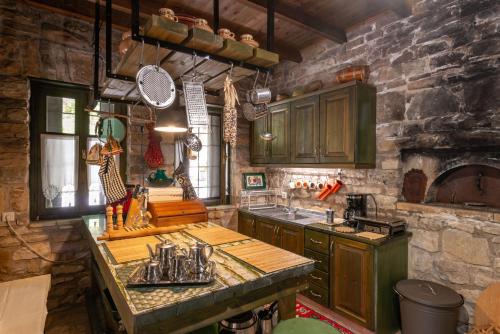 a kitchen with wooden cabinets and a stone wall at Liodentro - Olea in Plataria