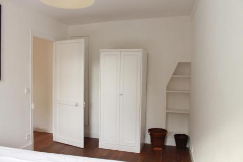 - une chambre avec des murs blancs et un placard blanc dans l'établissement Appartement dans le Marais, à Paris