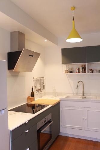 une cuisine avec des armoires blanches et un évier dans l'établissement Appartement dans le Marais, à Paris