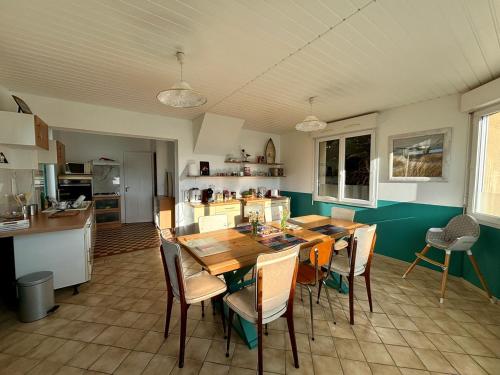 une cuisine et une salle à manger avec une table et des chaises dans l'établissement Villa Papyno - Maison 12 personnes - 10mn à pied de la plage - Val André, à Pléneuf-Val-André